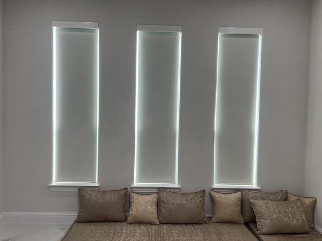 Roller shades on three tall windows