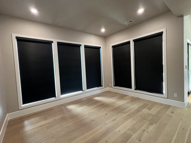 Black roller shades in a sunroom