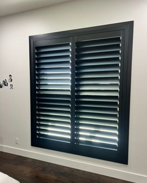 Black plantation shutters on a square window