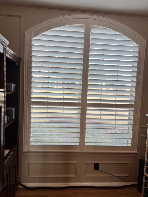 Arched plantation shutters on a tall window
