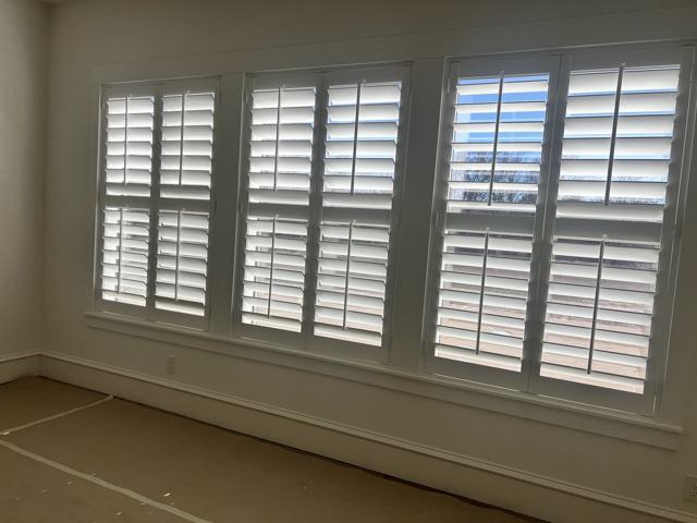 Plantation shutters across a three-window wall