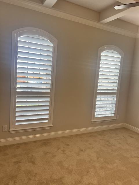 Arched plantation shutters in a bright room